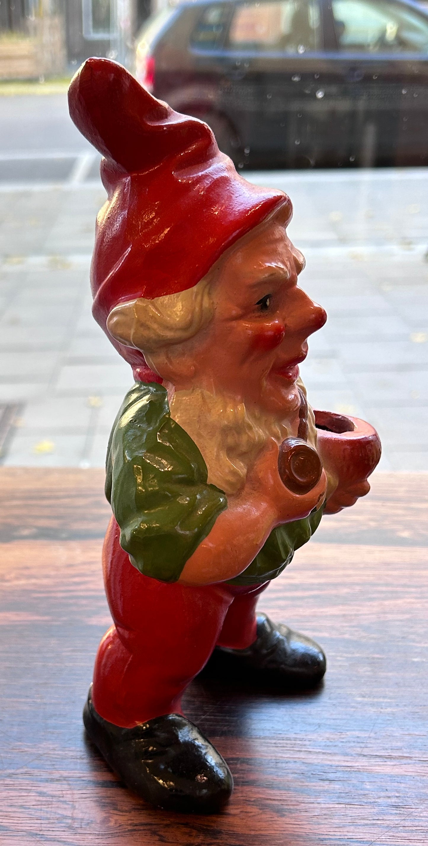 Äldre piprökande tomte med ljushållare, grön överkropp