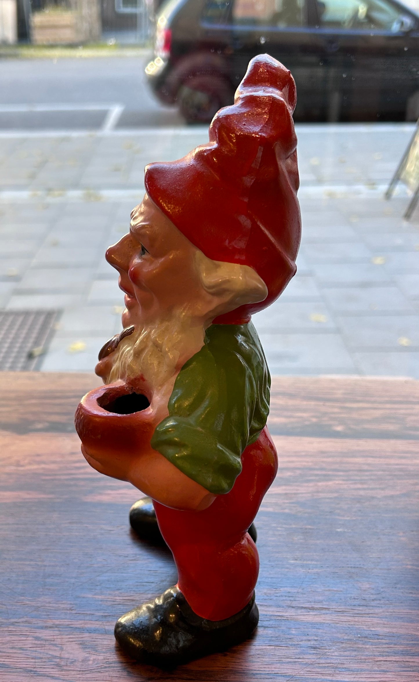 Äldre piprökande tomte med ljushållare, grön överkropp