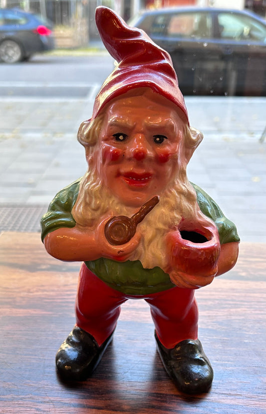 Äldre  piprökande  tomte med ljushållare, grön överkropp